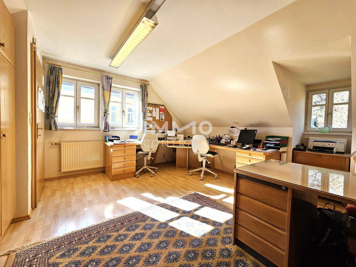 Geräumiges Dachgeschoss-Büro mit zwei Schreibtischen und viel Stauraum.