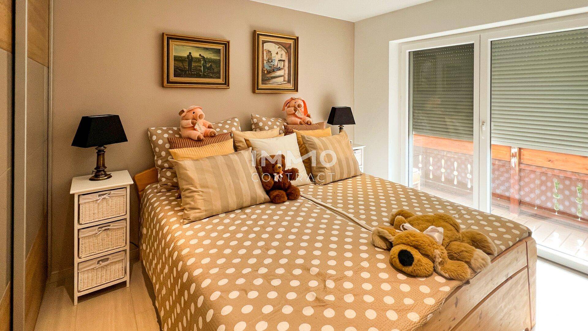 Kinderzimmer mit Doppelbett, Nachttischen und Rollladen am Fenster.
