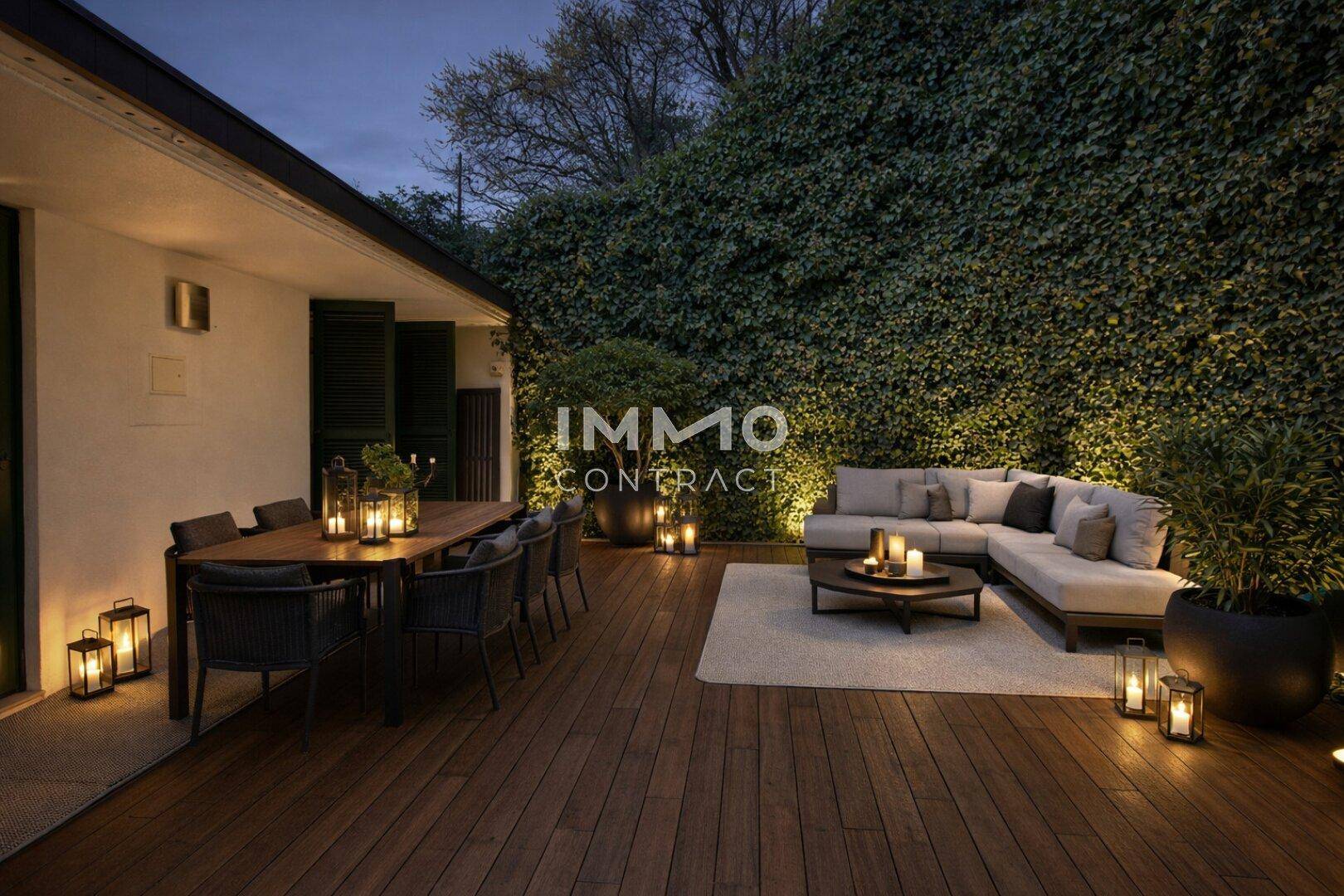 Stimmungsvolle Terrasse am Abend mit Esstisch und Lounge-Bereich, beleuchtet von Laternen.