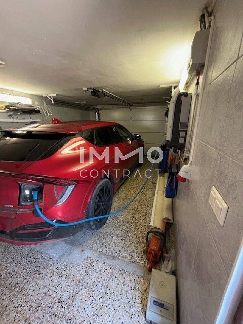 Garage mit Ladestation für Elektrofahrzeuge und ausreichend Platz für ein Auto.