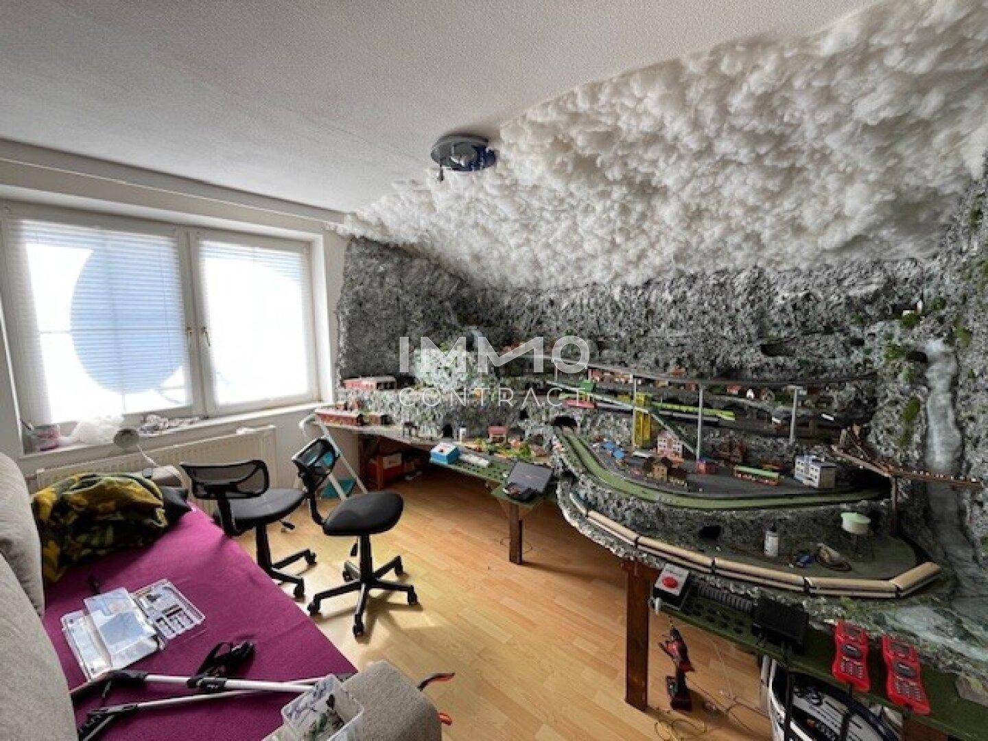 Kreativer Raum mit Modellbaulandschaft und Holzboden, ideal für Hobbys und Freizeitaktivitäten.