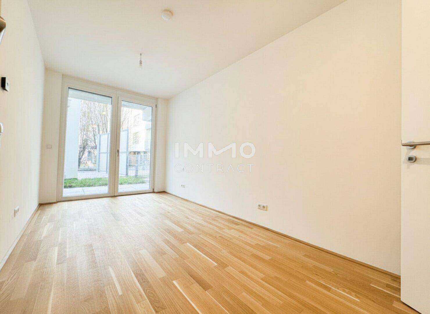 Helles Schlafzimmer mit Eichenparkettboden und großen Fenstern, die viel Tageslicht hereinlassen.