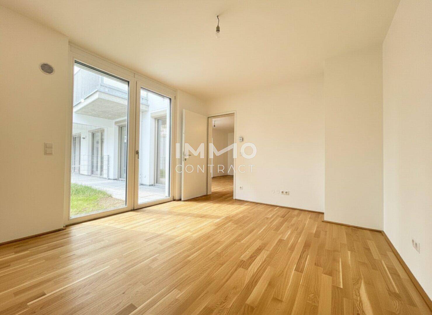 Geräumiger, heller Wohnbereich mit Eichenparkett und bodentiefen Fenstern zum Außenbereich.