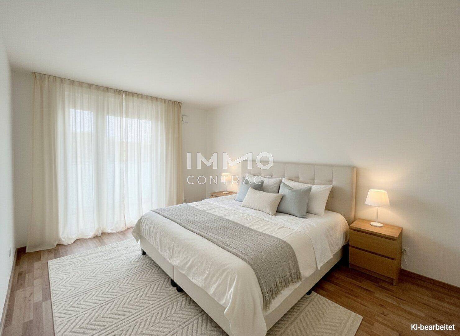 Helles Schlafzimmer mit Doppelbett, Nachttischen und Vorhängen, die den Zugang zum Balkon verdecken.