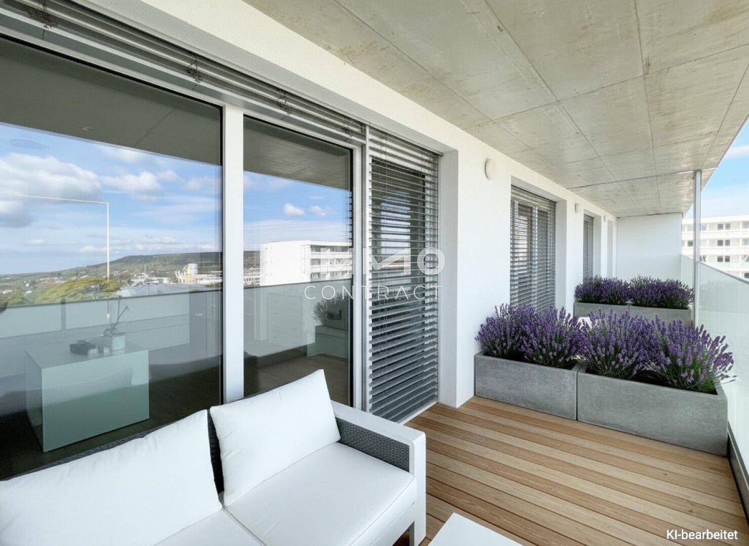 Heller Balkon mit Holzfußboden, bequemen Sitzmöbeln und Lavendelpflanzen, bietet einen schönen Ausblick.