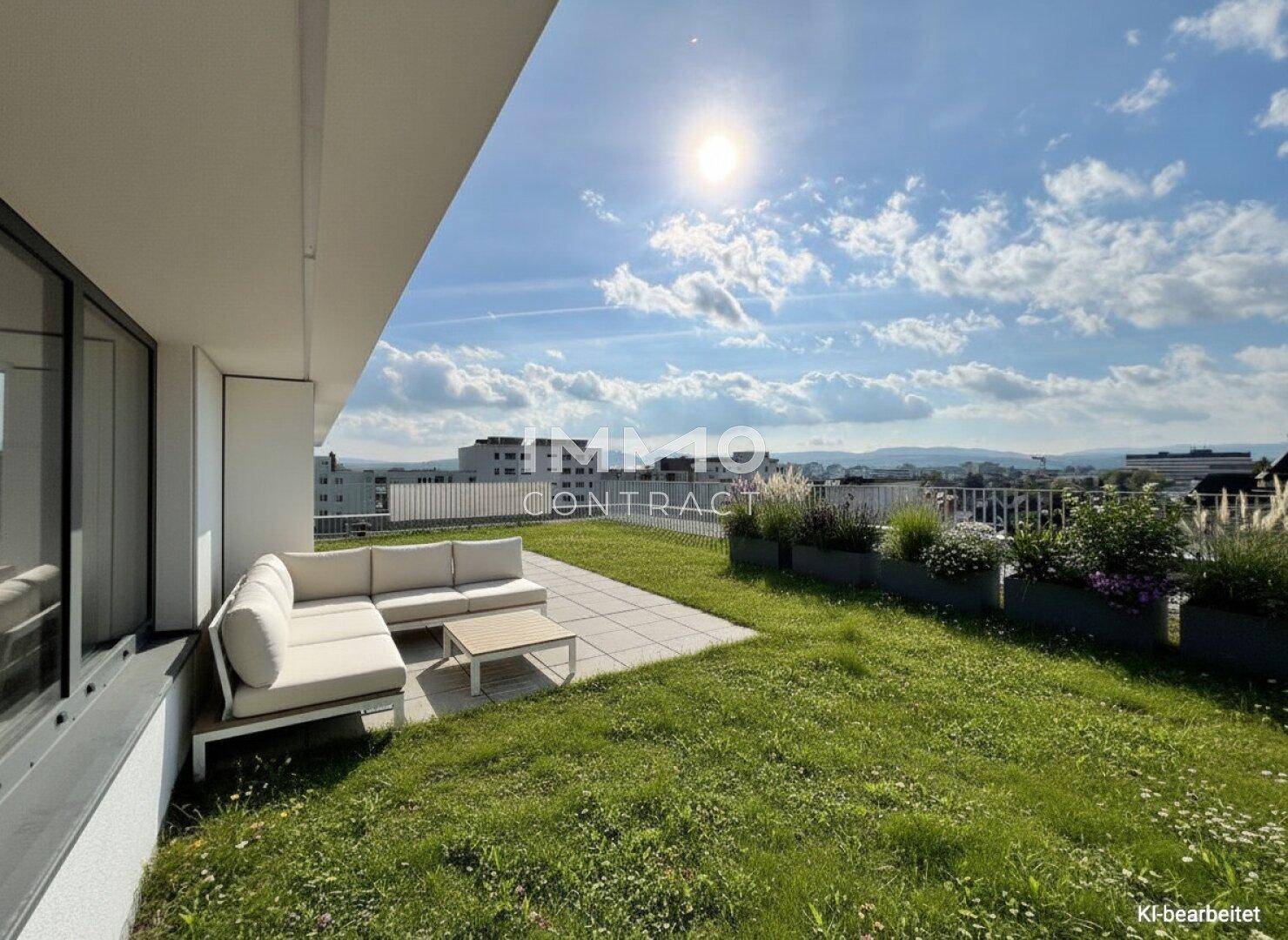 Grüne Dachgartenfläche mit Sitzgelegenheit und weitem Blick über die Landschaft unter blauem Himmel.