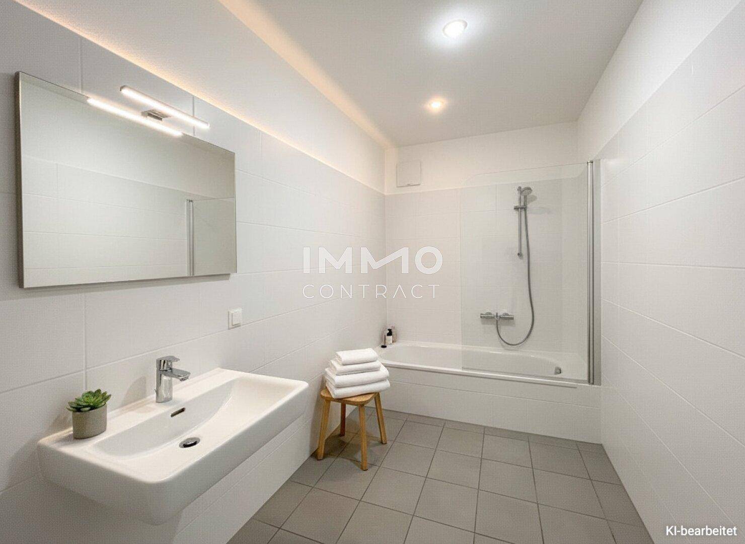 Modernes Badezimmer mit Badewanne, Dusche und weiß gefliesten Wänden, hell und funktional.