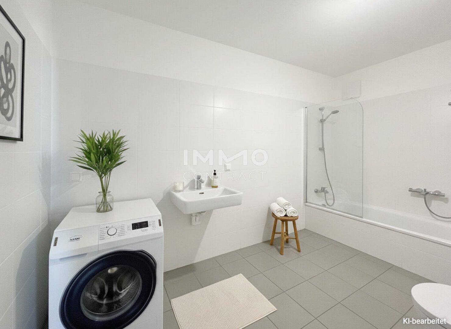 Funktionales Badezimmer mit Waschmaschine, Waschbecken und Badewanne mit Duschfunktion.