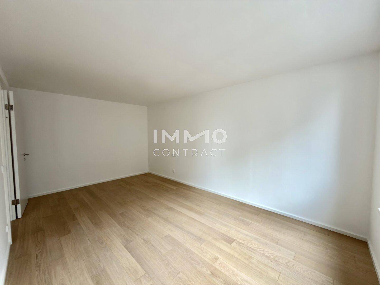 Leeres Zimmer mit hellem Parkettboden und weißen Wänden, bereit zur individuellen Gestaltung.