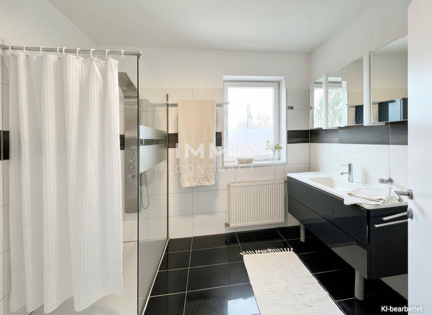 Modernes Badezimmer mit dunklen Fliesen, großer Duschkabine und einem Fenster für Tageslicht.