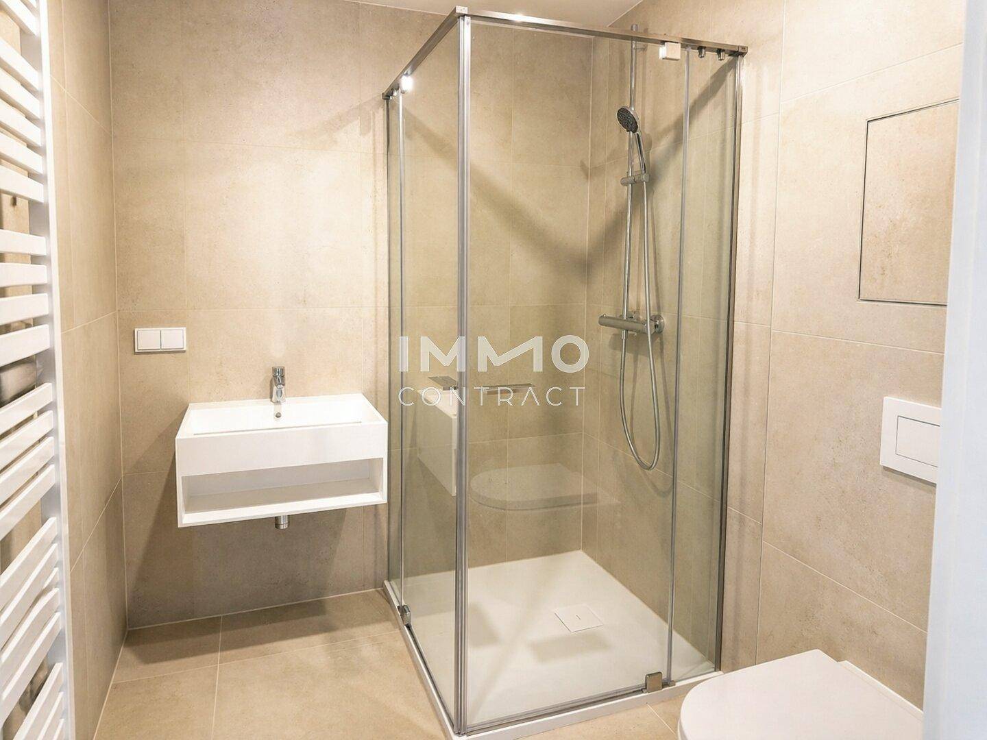 Modernes Badezimmer mit begehbarer Dusche, Wand-WC und beheiztem Handtuchhalter in neutralen Farbtönen.