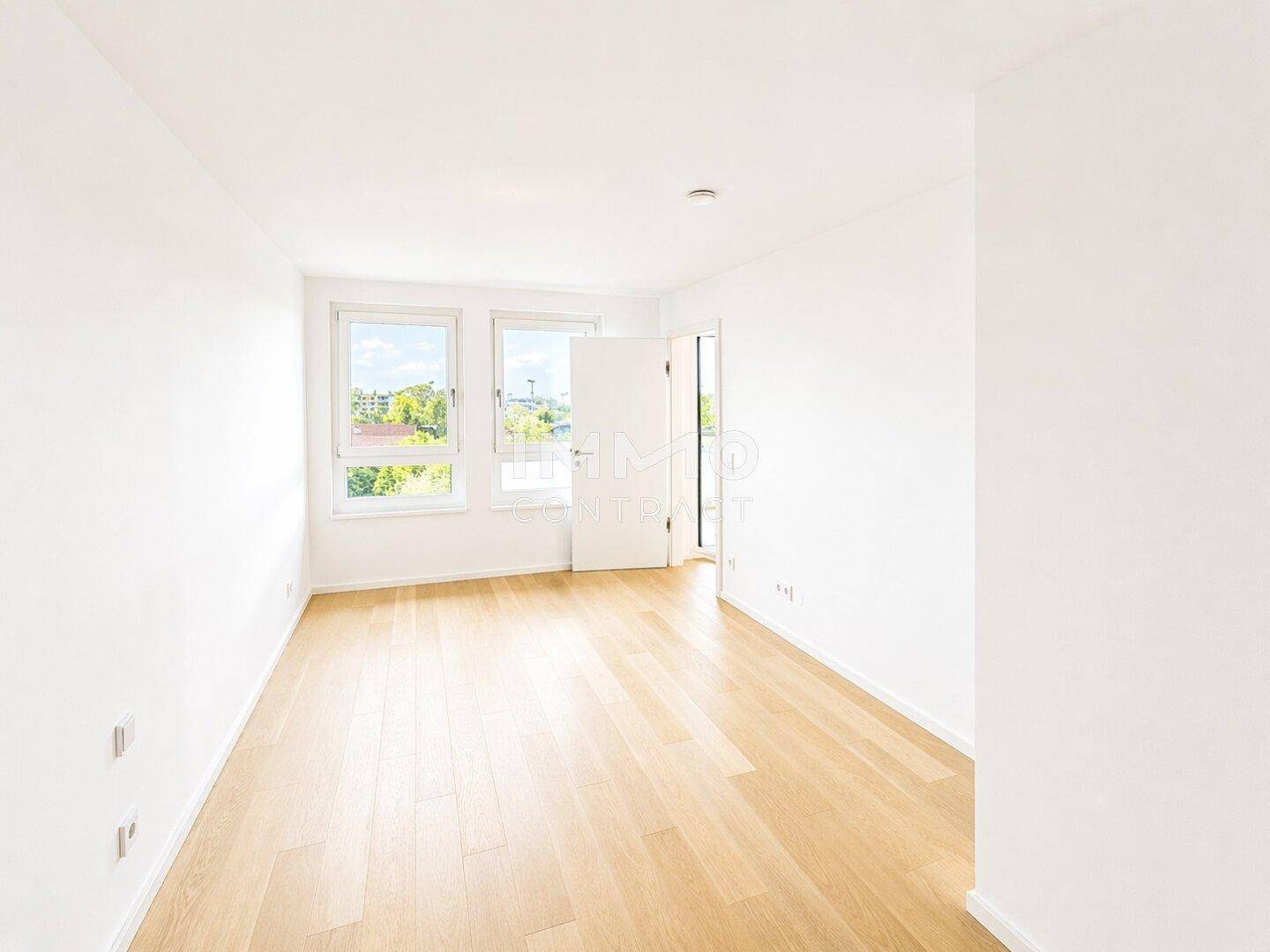 Helles Schlafzimmer mit Holzboden und zwei Fenstern, bietet viel natürliches Licht.