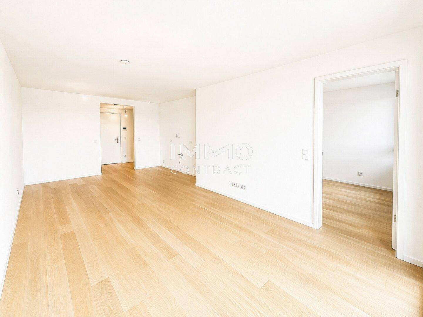 Geräumiger, heller Raum mit Holzboden und weißen Wänden, bereit zur individuellen Gestaltung.