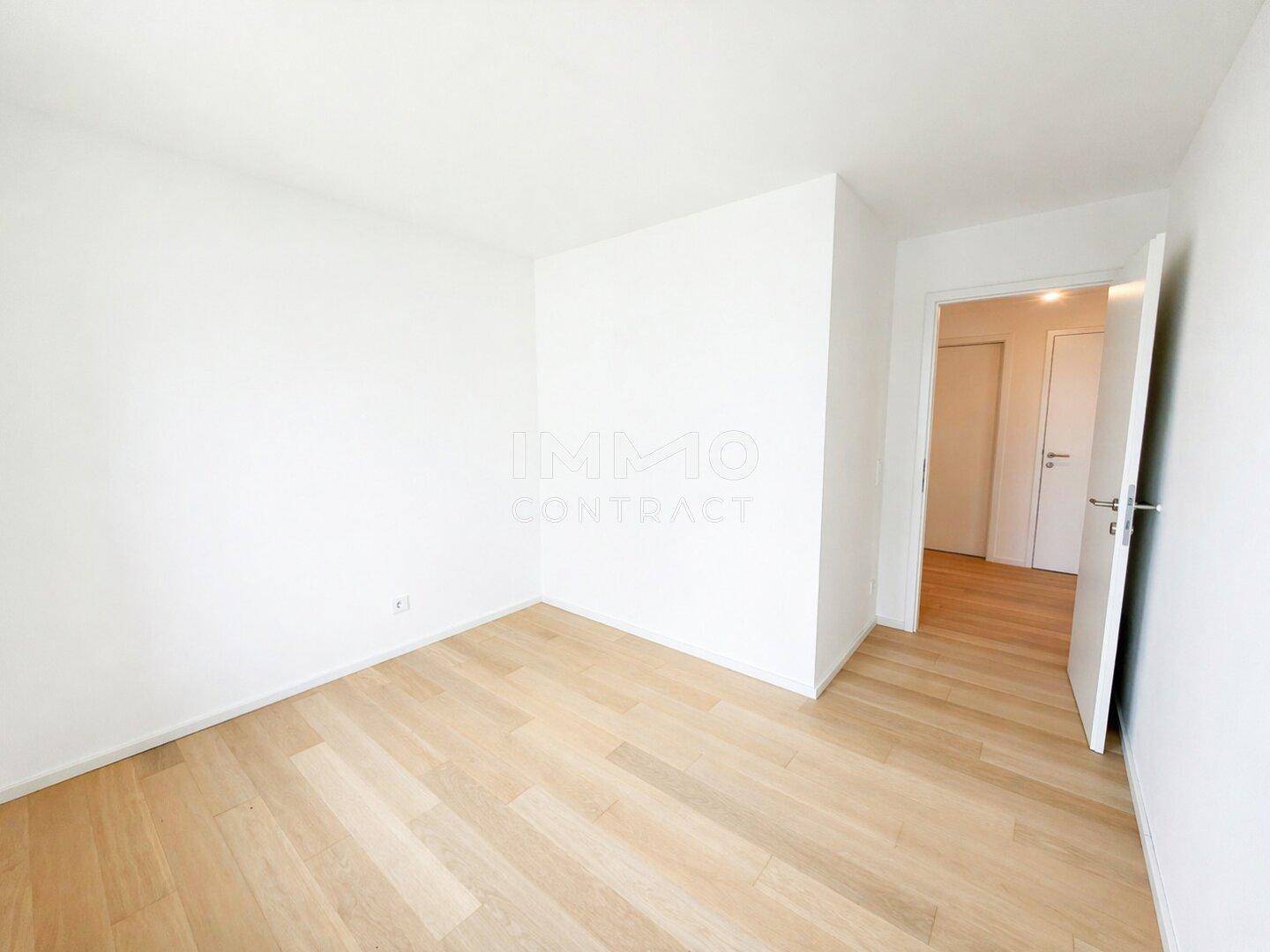 Leeres Schlafzimmer mit hellem Parkettboden und weißen Wänden, bereit zum Einrichten.