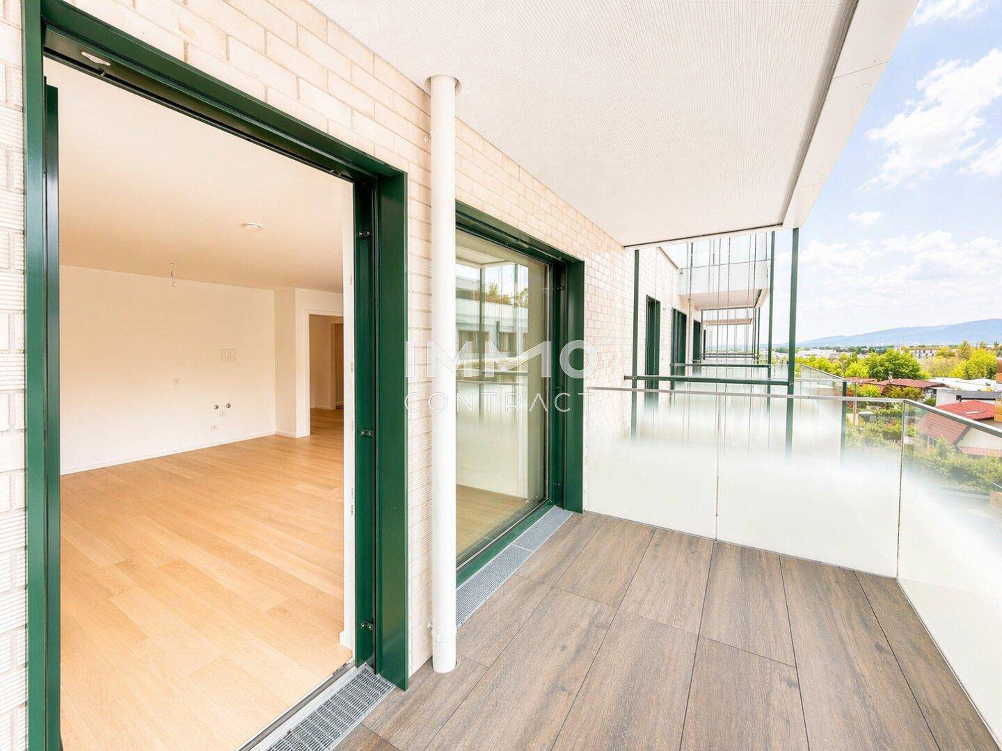 Geräumiger Balkon mit Glasbrüstung und weitem Blick über die Landschaft.
