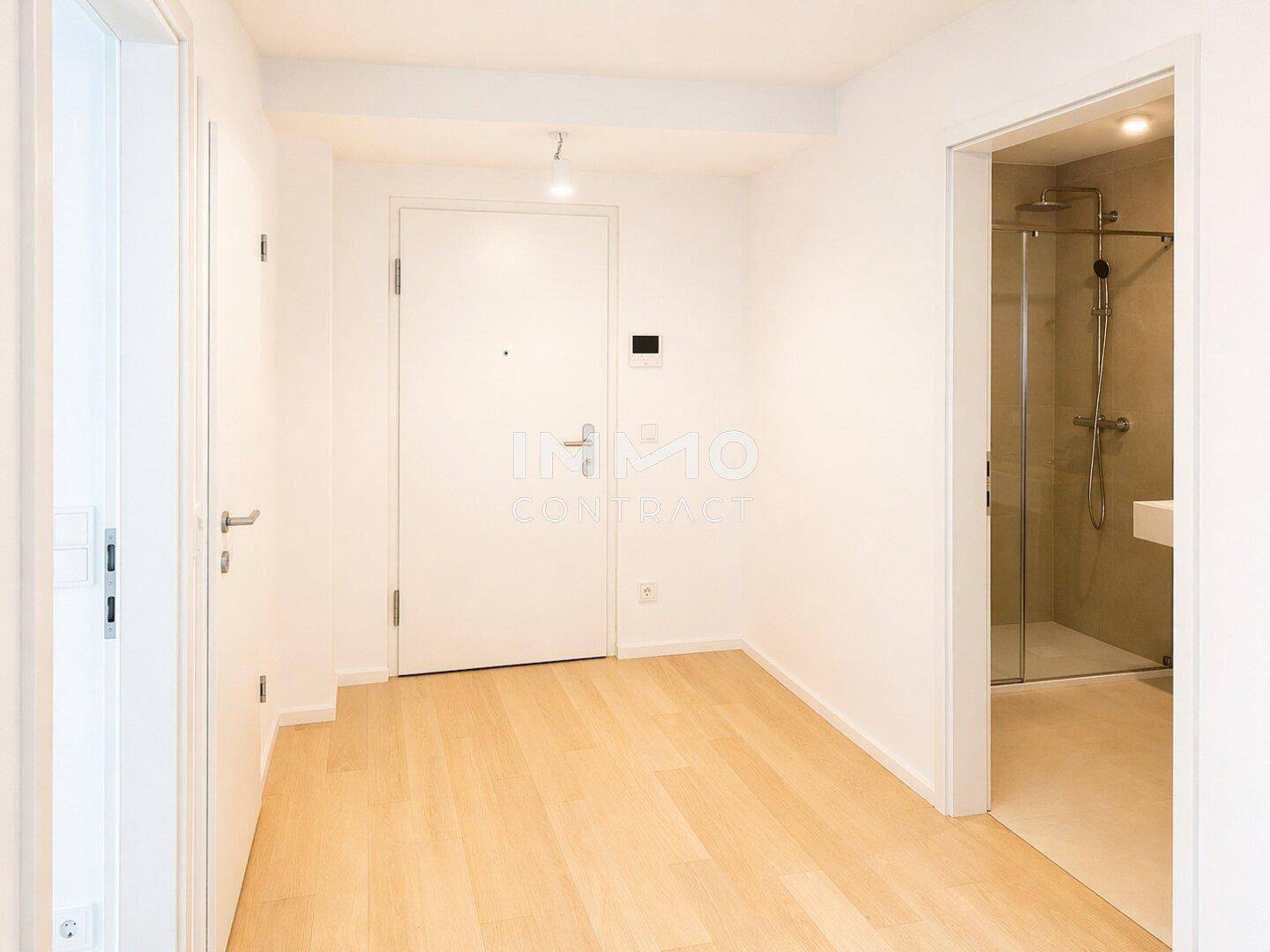 Heller Flur mit Parkettboden und Zugang zu verschiedenen Räumen, inklusive Badezimmer.