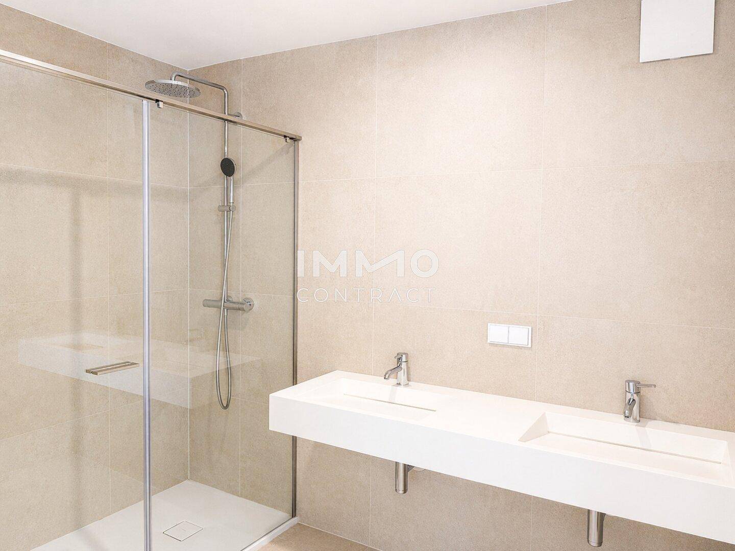 Modernes Badezimmer mit beigefarbenen Fliesen, Doppelwaschbecken und ebenerdiger Dusche.