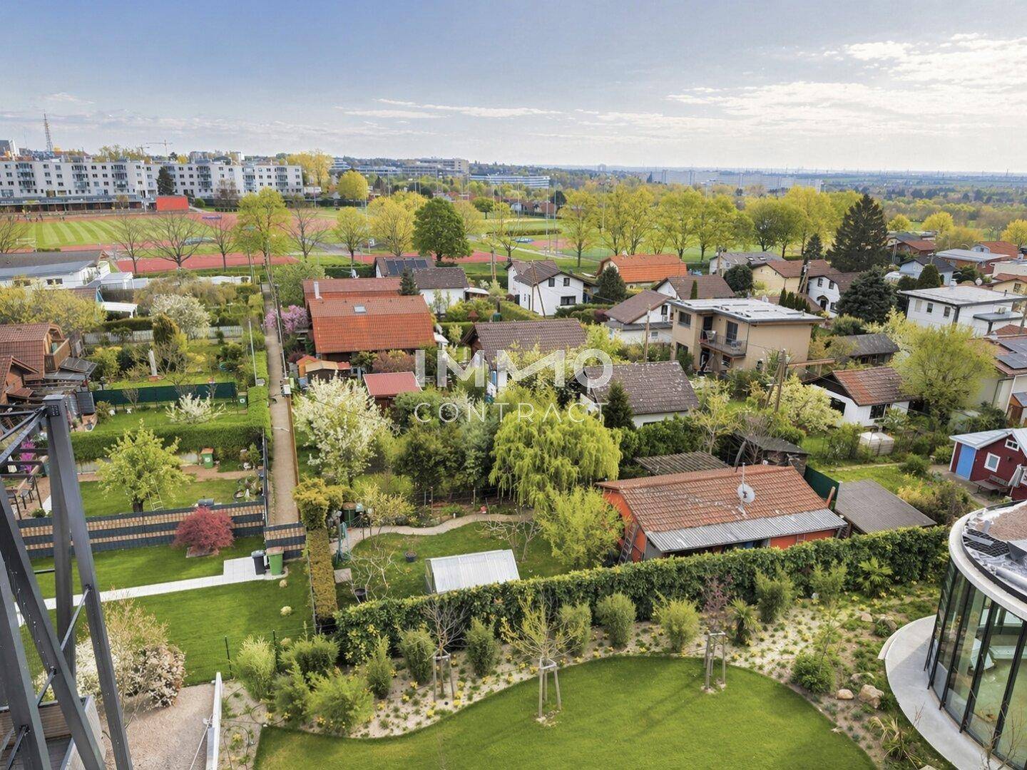 Weitläufiger Blick über die grüne Wohngegend mit Einfamilienhäusern und Sportanlagen.