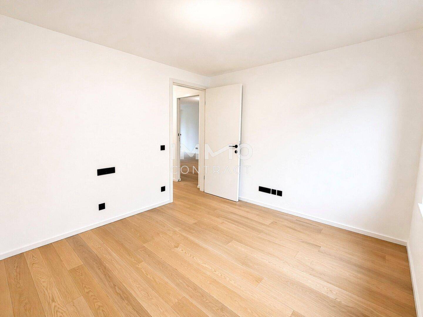 Helles, unmöbliertes Zimmer mit Parkettboden und weiß gestrichenen Wänden, ideal als Schlafzimmer.