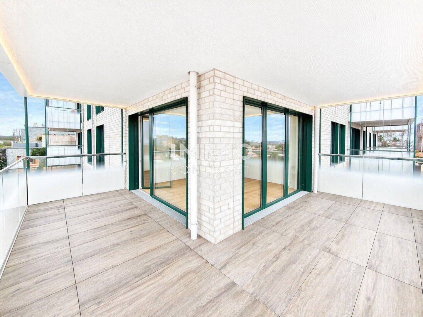 Geräumiger Balkon mit Fliesenboden und Ziegelwand, bietet Zugang zu hellen Innenräumen.