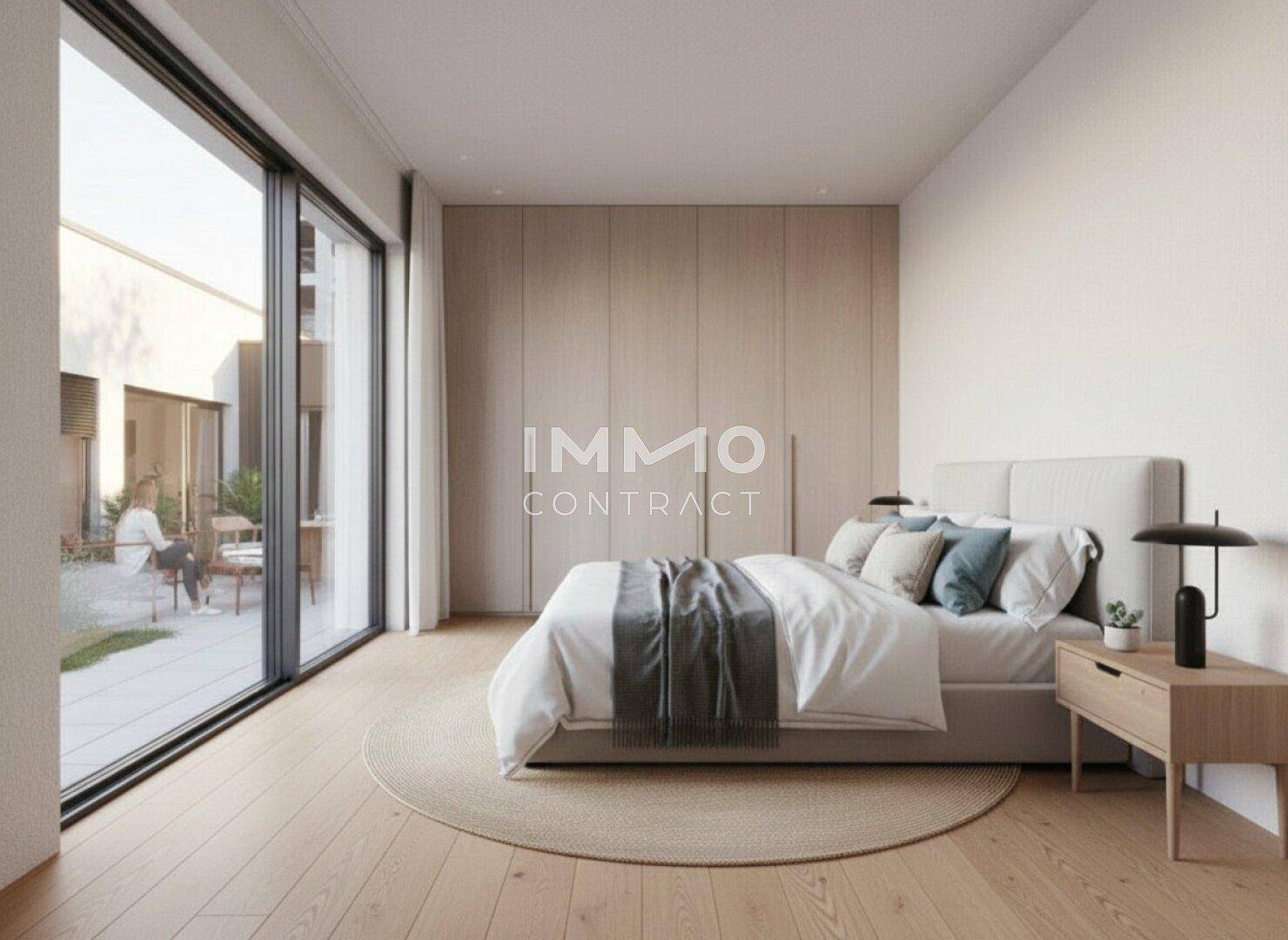 Helles Schlafzimmer mit Holzboden, Einbauschränken und großem Fenster zur Terrasse.