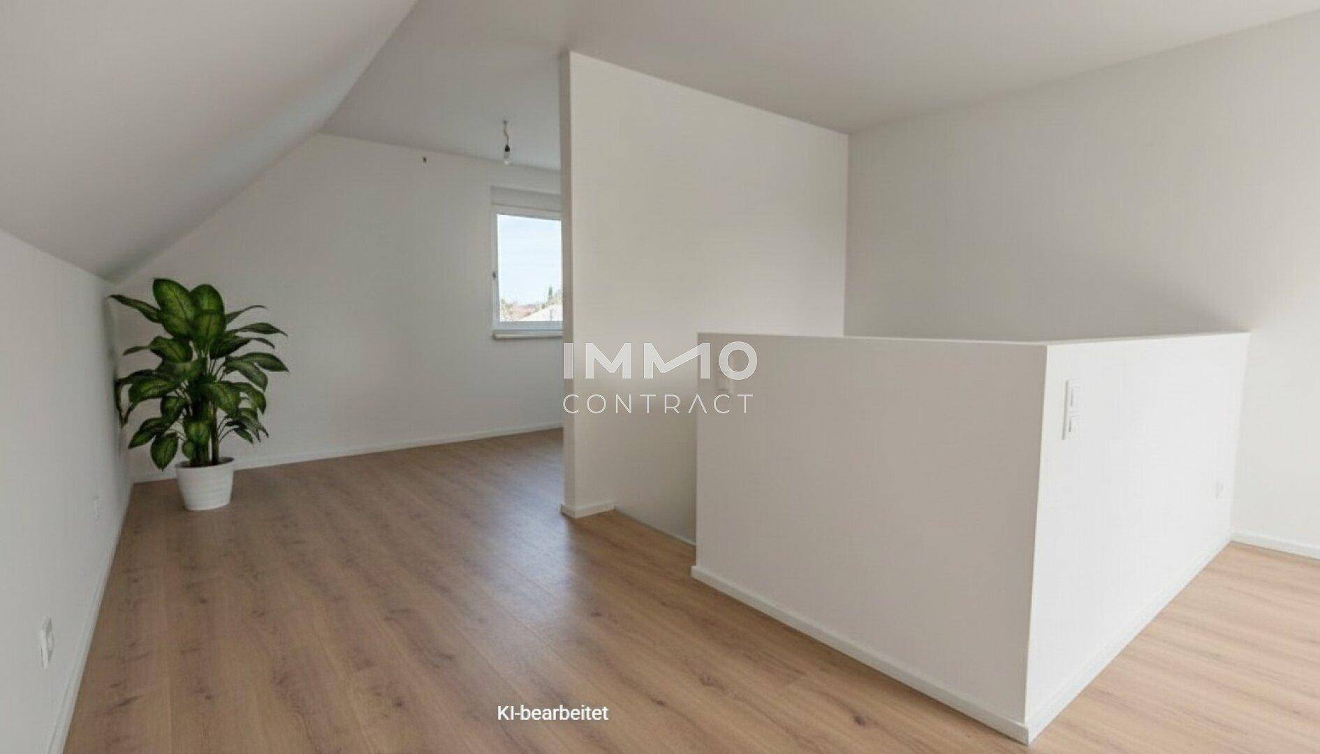 Offener Dachbodenbereich mit Laminatboden, viel Tageslicht und einer Zimmerpflanze.