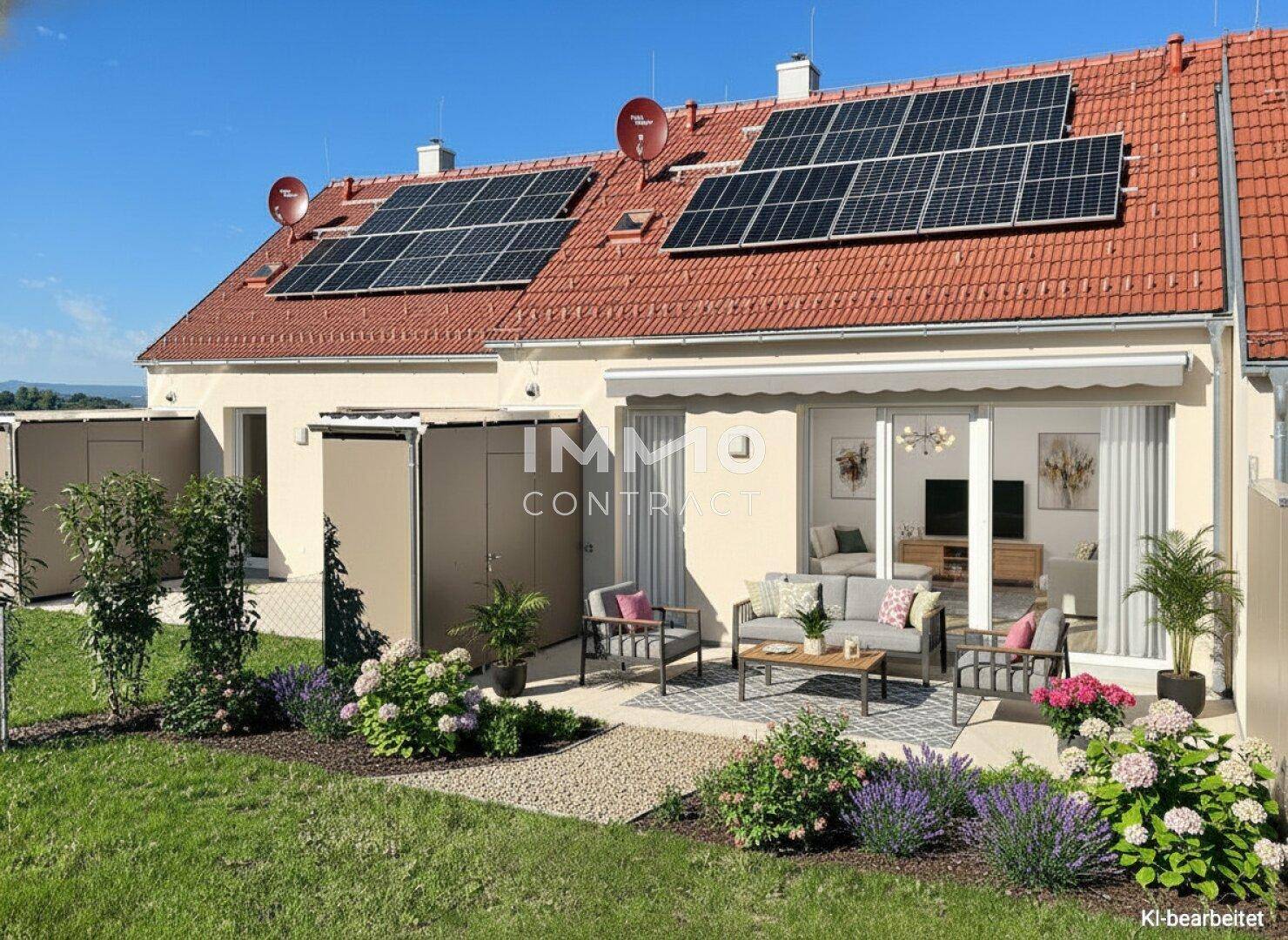 Rückseite eines Reihenhauses mit möblierter Terrasse, Garten und Photovoltaikanlage auf dem Ziegeldach.