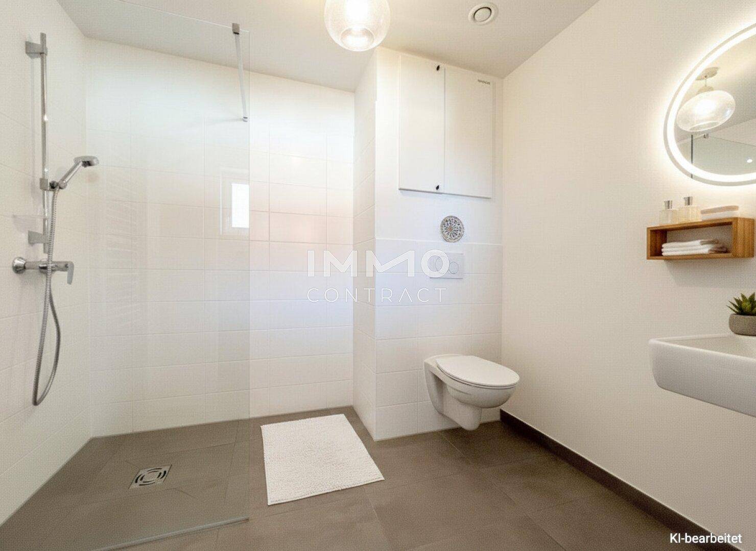 Helles Badezimmer mit großer ebenerdiger Dusche, wandhängendem WC und modernem Waschtisch mit beleuchtetem Spiegel.