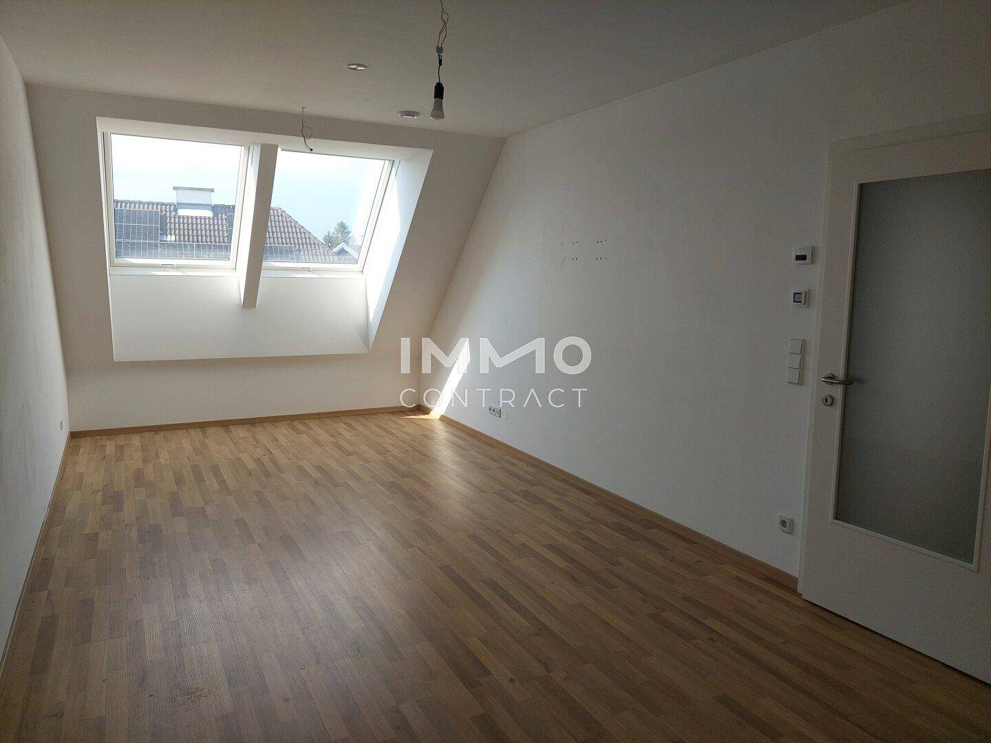 Heller Raum im Dachgeschoss mit Parkettboden und zwei großen Dachfenstern.