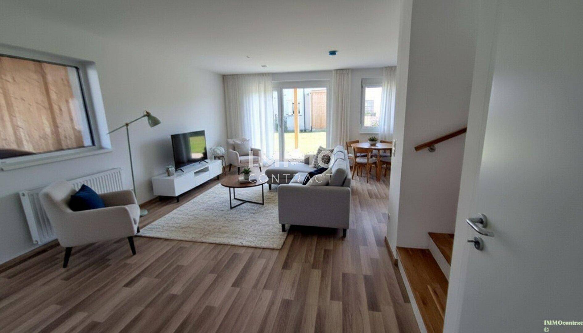 Heller Wohn- und Essbereich mit Holzfußboden und Zugang zum Garten.