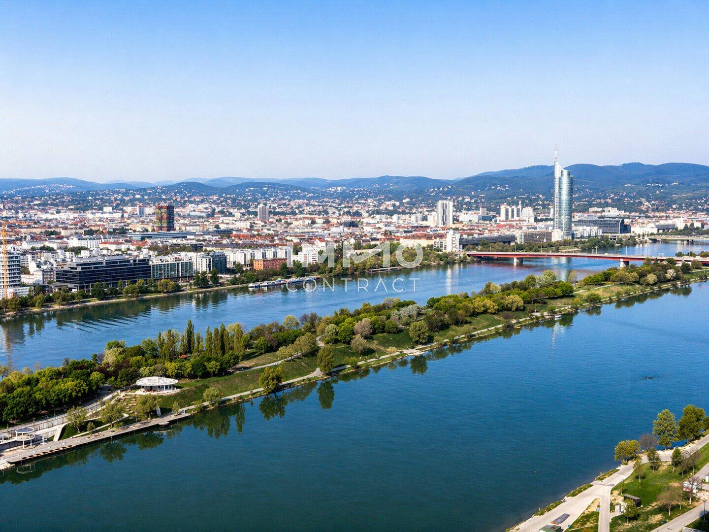 Beeindruckender Ausblick auf die Stadt, den Fluss und die Berge im Hintergrund an einem sonnigen Tag.