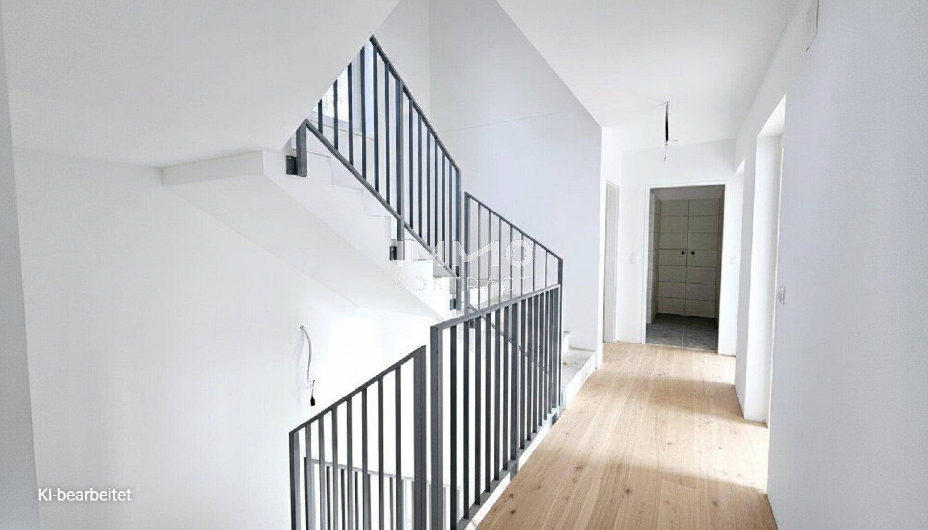 Heller Flur mit moderner Treppe und Holzboden, der zu weiteren Räumen führt.