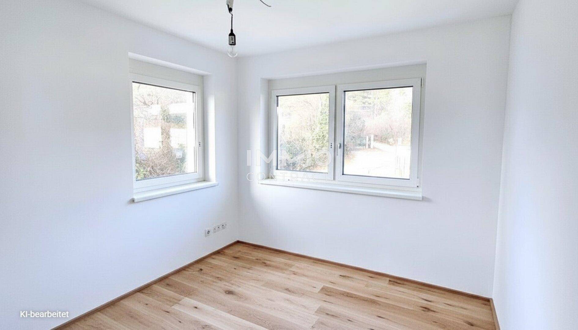Freundliches Zimmer mit zwei Fenstern und hellem Holzboden, ideal als Schlaf- oder Arbeitszimmer.