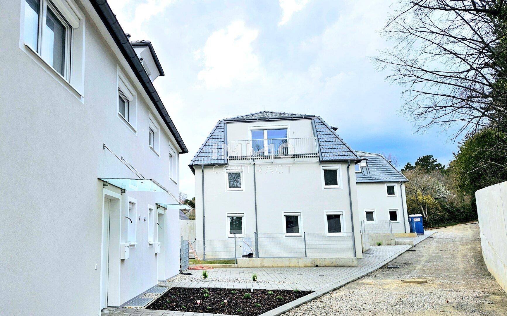 Reihe von Neubauhäusern mit moderner Architektur und Blick auf die Umgebung.