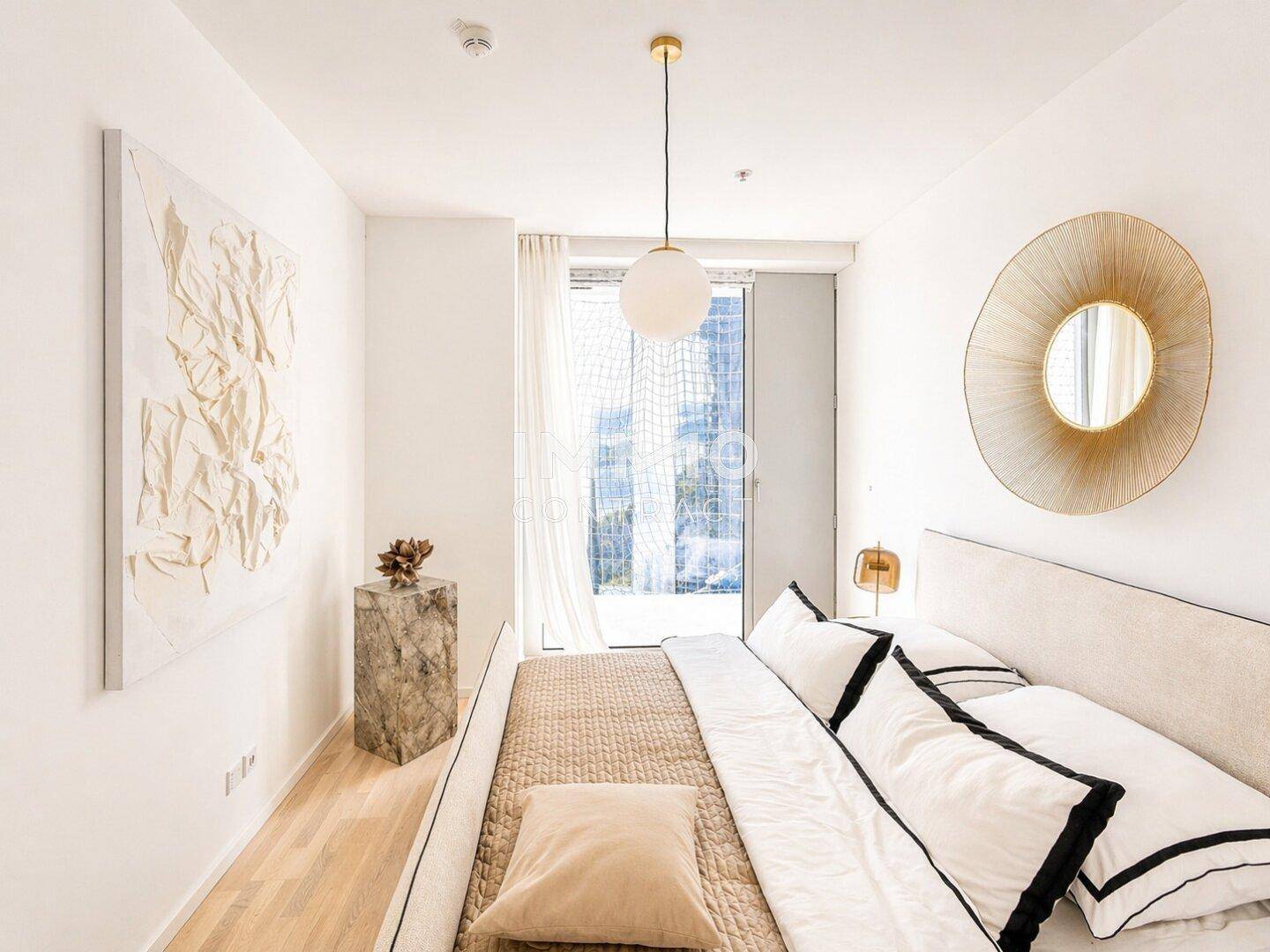 Modernes Schlafzimmer mit hellem Holzboden, minimalistischer Einrichtung und Zugang zu einem Balkon.
