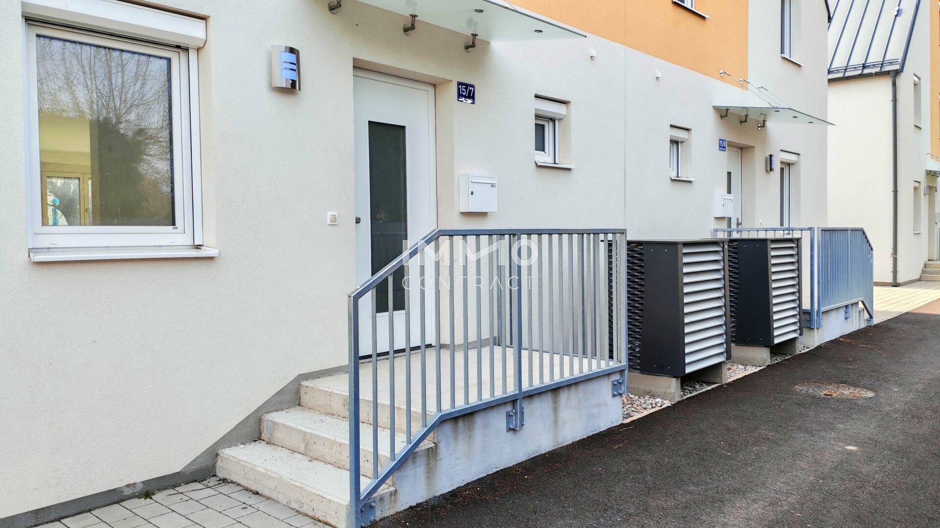 Eingangsbereich eines Reihenhauses mit kleiner Treppe und Briefkasten.