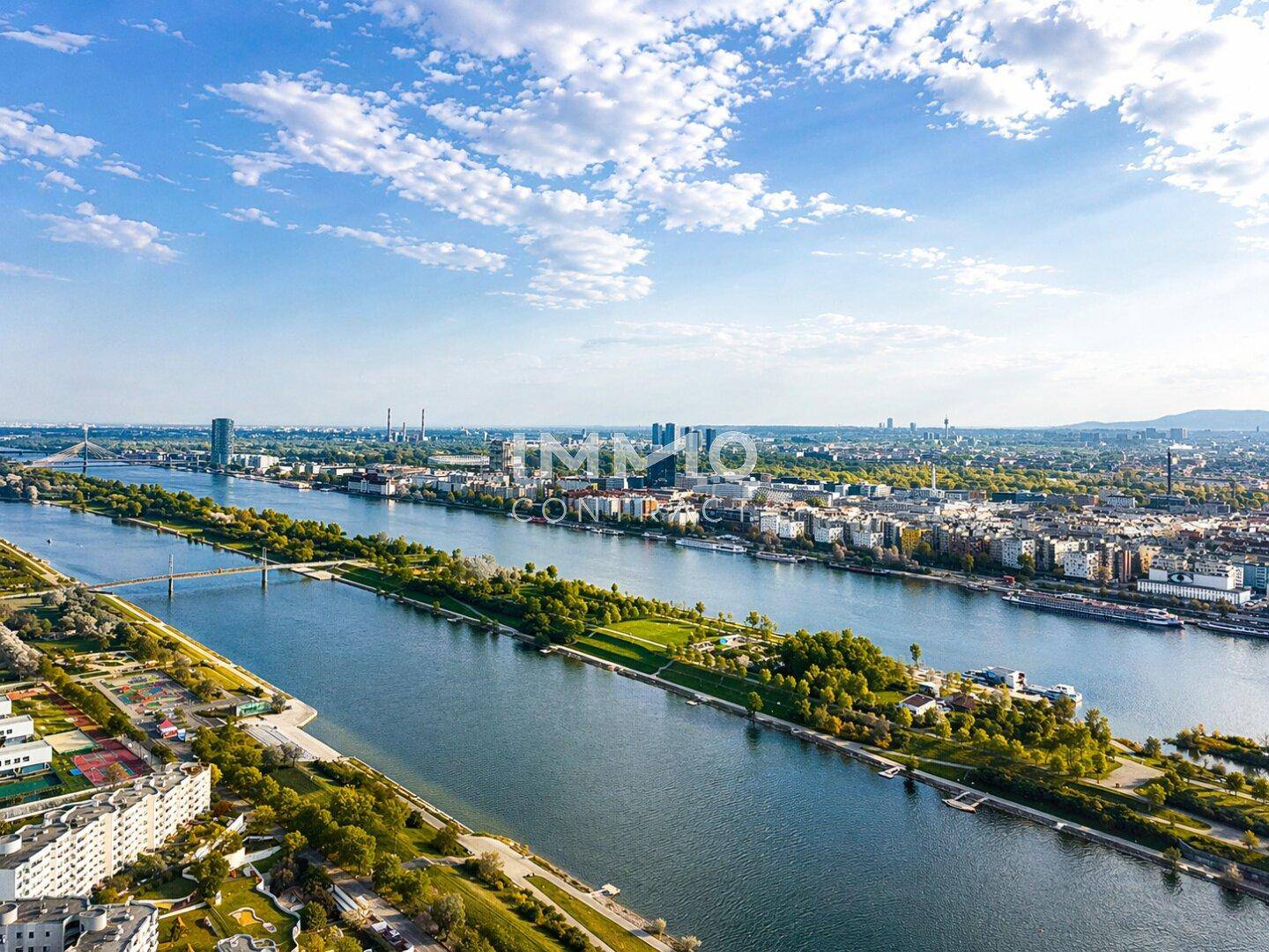 Weitläufiger Panoramablick über die Stadt, den Fluss und die umliegende grüne Landschaft.