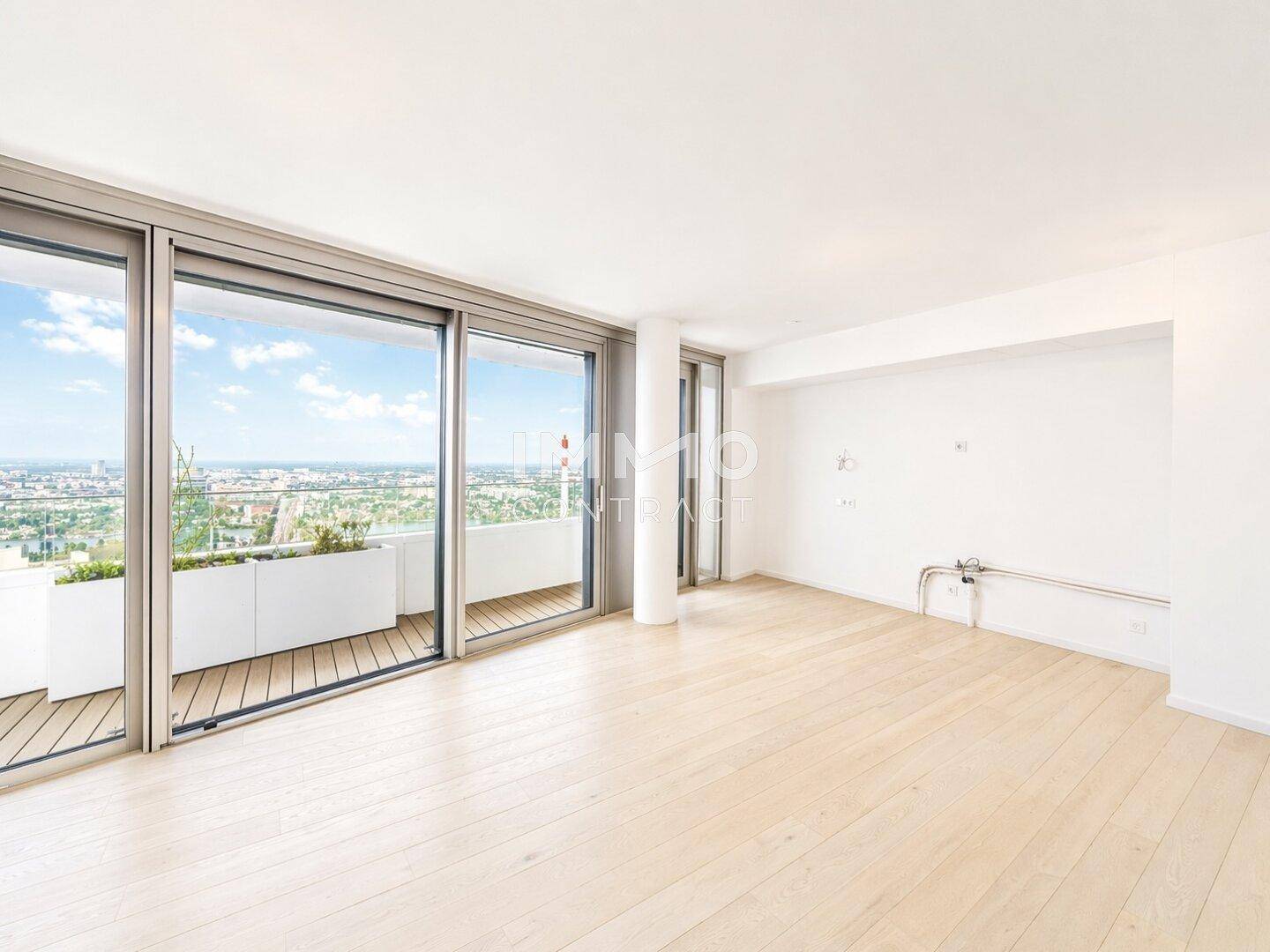 Heller Wohnraum mit Holzboden und großen Fenstern, bereit für individuelle Gestaltung und mit Stadtblick.