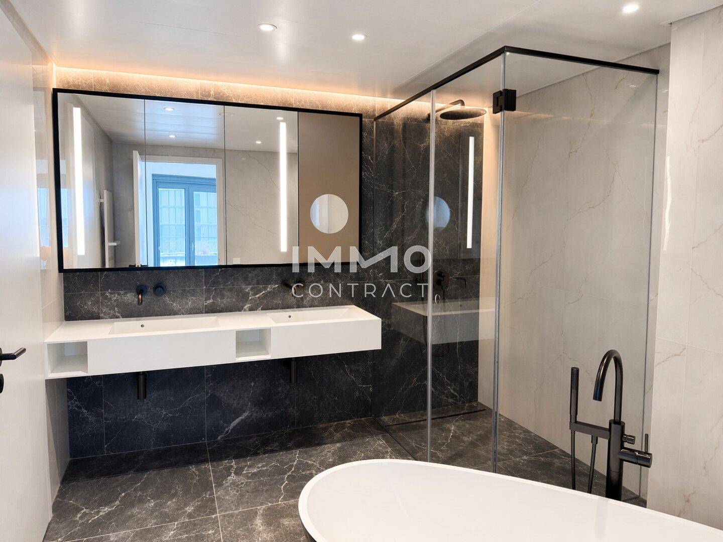 Luxuriöses Badezimmer mit Doppelwaschbecken, großer Spiegelschrank und begehbarer Dusche.