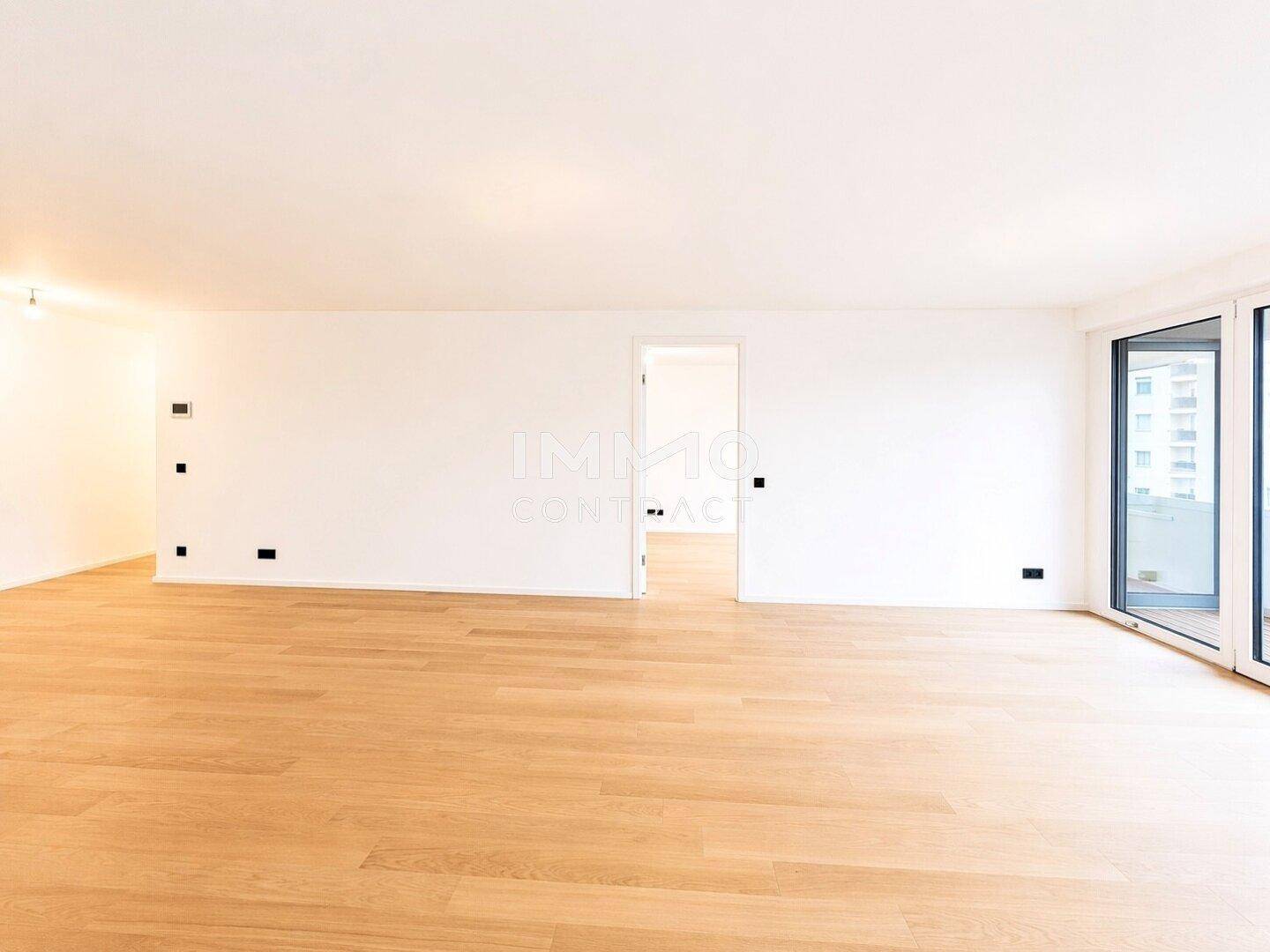 Geräumiges, helles Zimmer mit Holzboden und großen Fenstern, bereit zur individuellen Gestaltung.