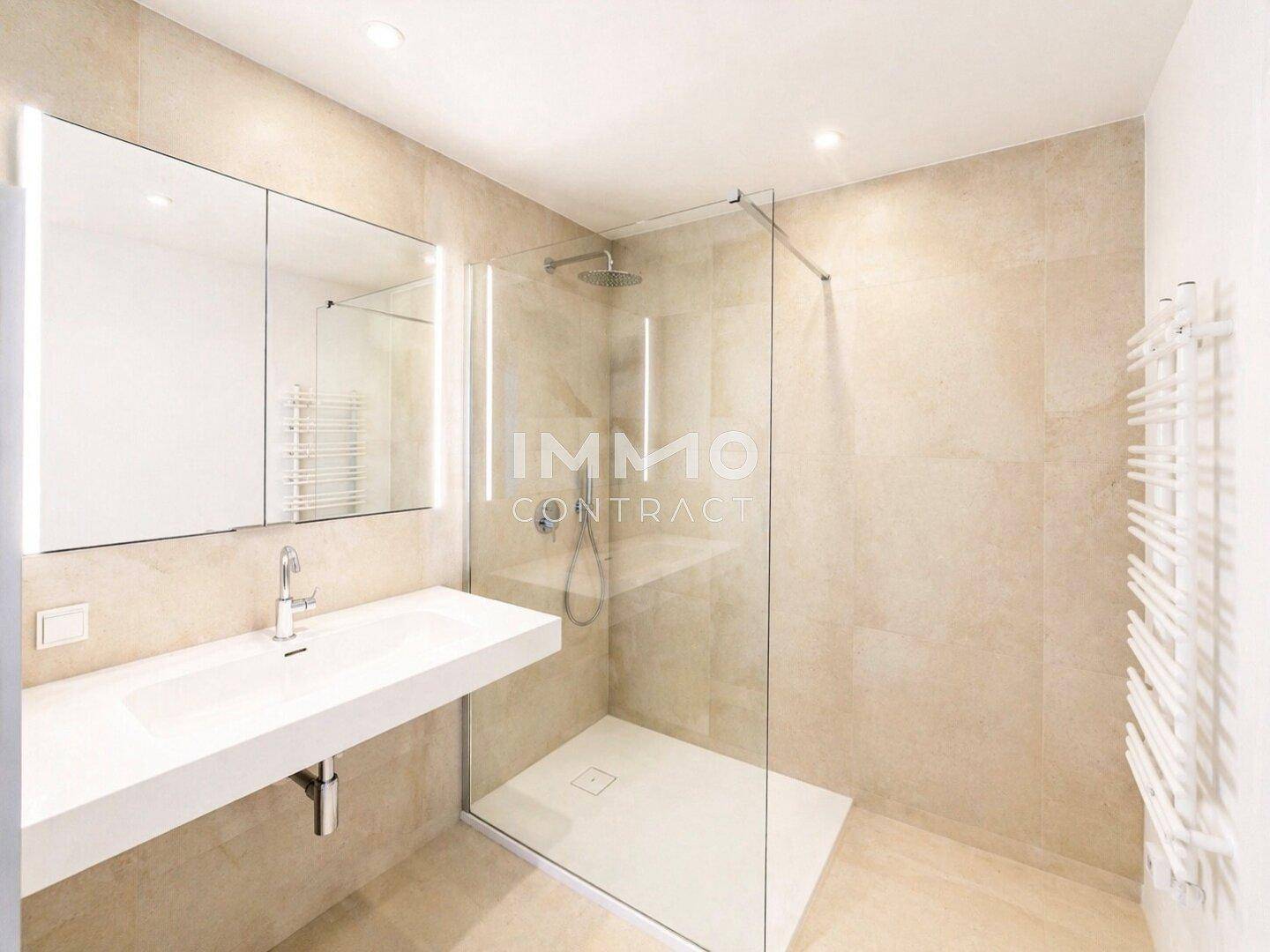 Modernes Badezimmer mit begehbarer Dusche, Einzelwaschbecken und beheiztem Handtuchhalter.