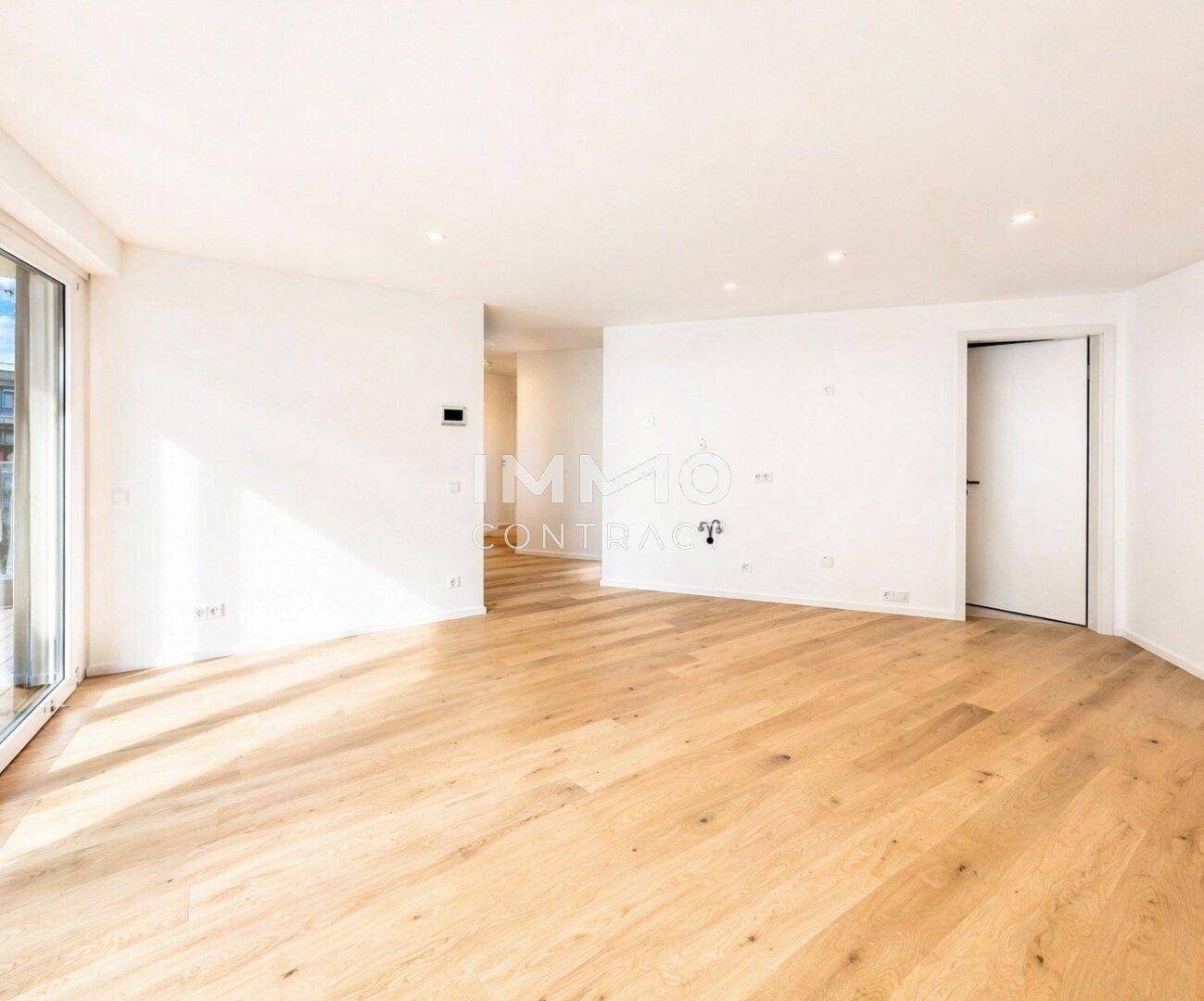 Lichtdurchfluteter Raum mit Holzboden und Zugang zu einem Außenbereich, ideal für offenes Wohnen.