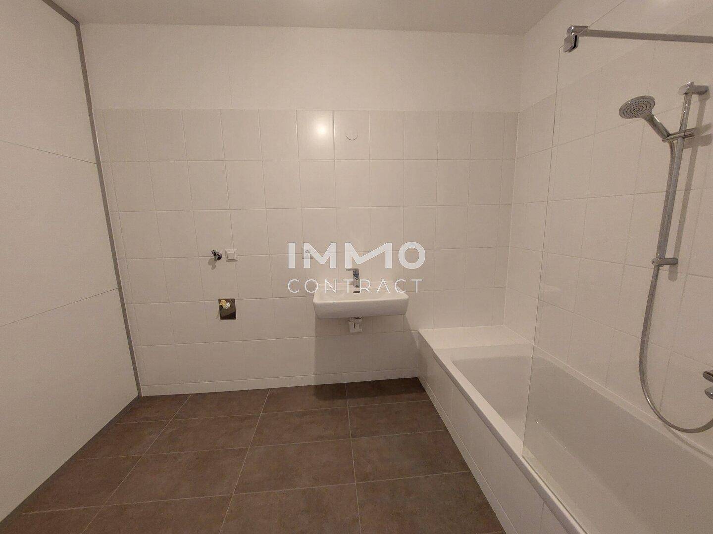 Modernes Badezimmer mit Badewanne, Duschvorrichtung und weißen Wandfliesen.