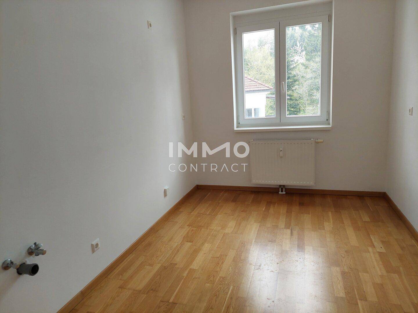Leerer Raum mit Parkettboden und Fenster, bereit zur individuellen Gestaltung.