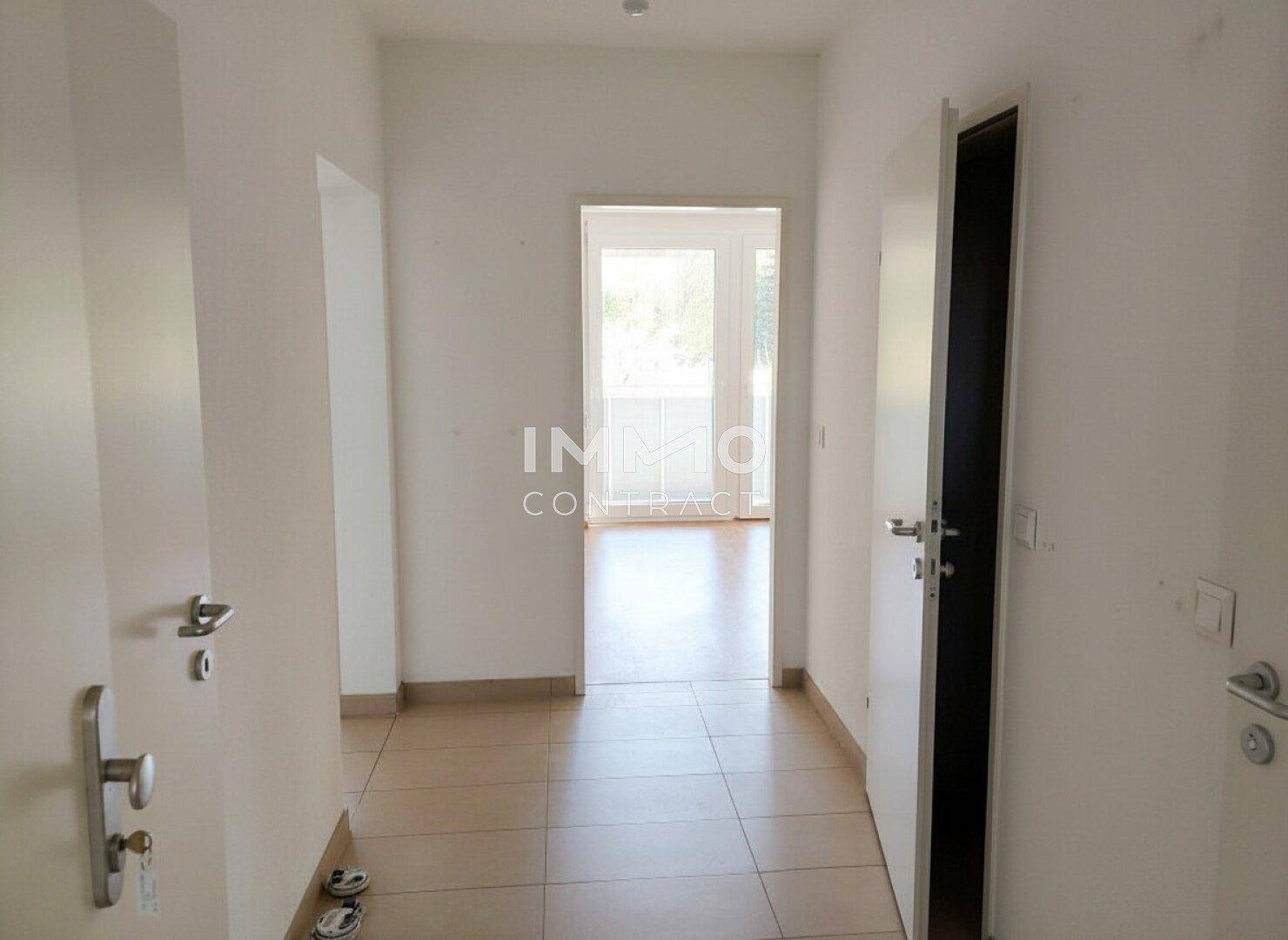 Heller Flur mit Fliesenboden und Zugang zu weiteren Räumen und Balkon.