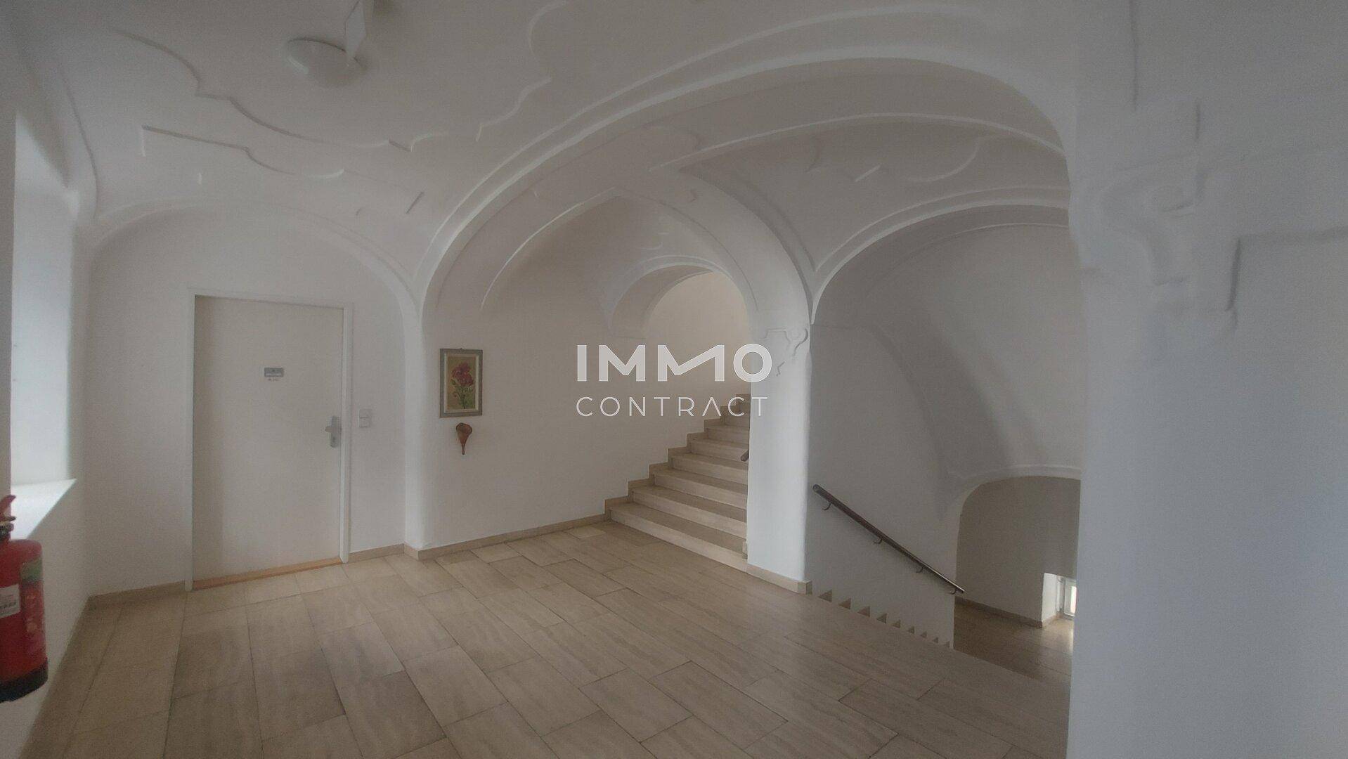 Eingangsbereich mit eleganter Treppe, gewölbten Decken und Fliesenboden, der zum Obergeschoss führt.