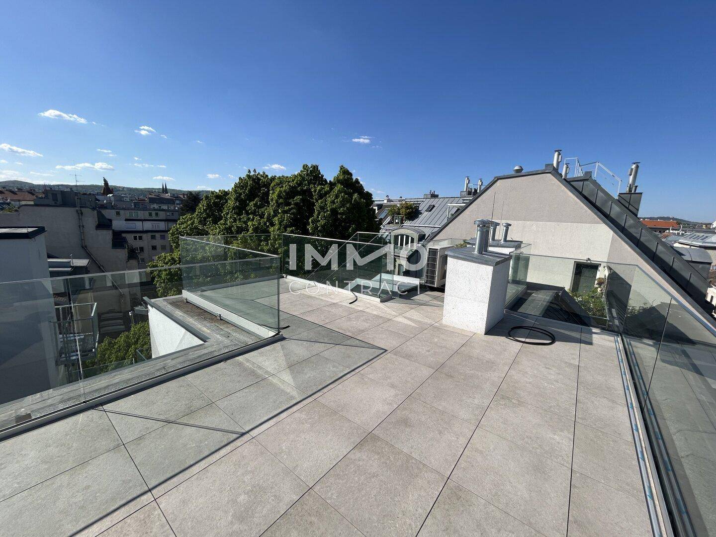 Geräumige Dachterrasse mit modernem Glasgeländer und weitem Blick über die Umgebung.