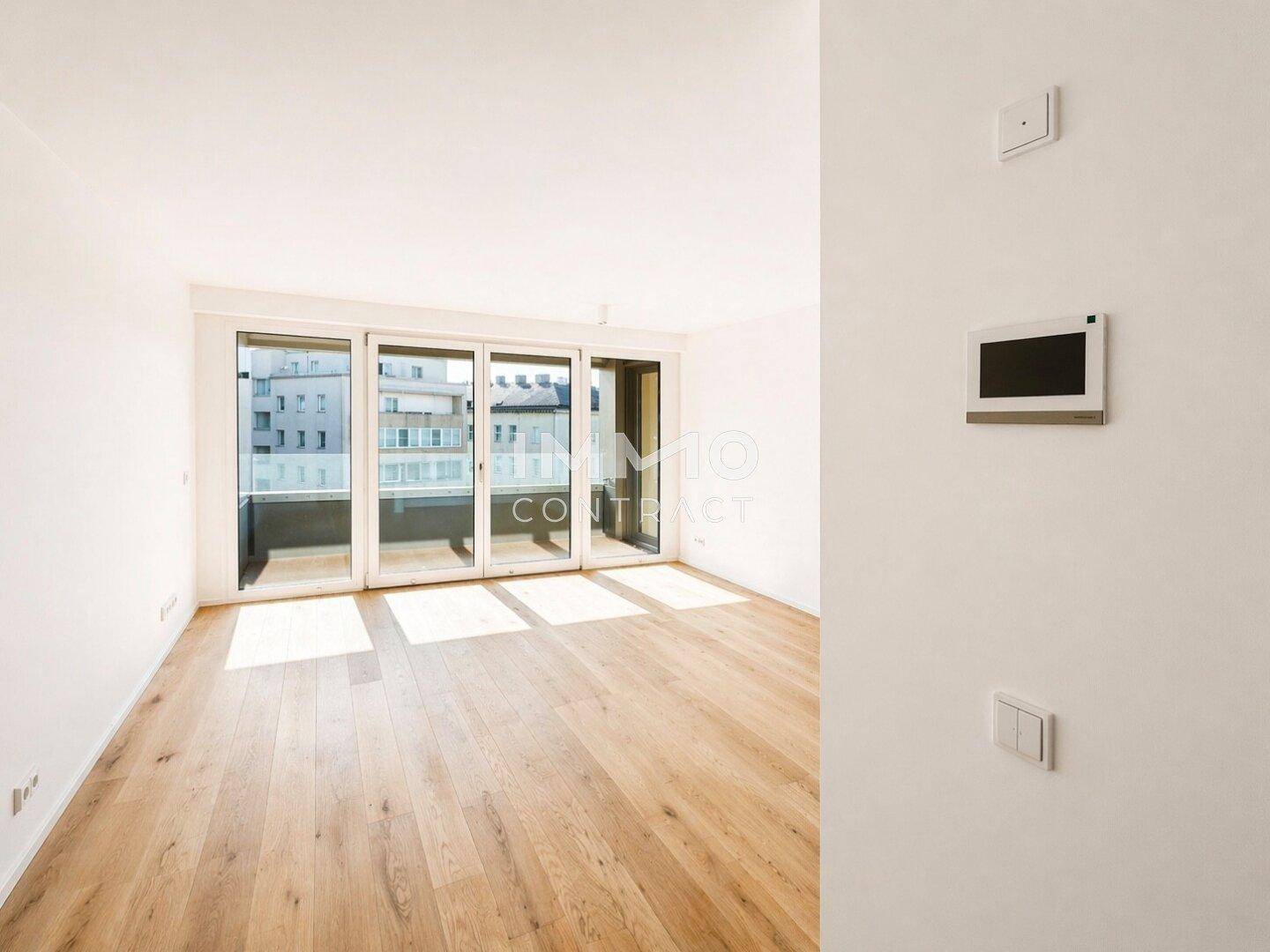 Heller Wohnraum mit Eichenparkett und großen Schiebetüren zum Balkon, lichtdurchflutet.