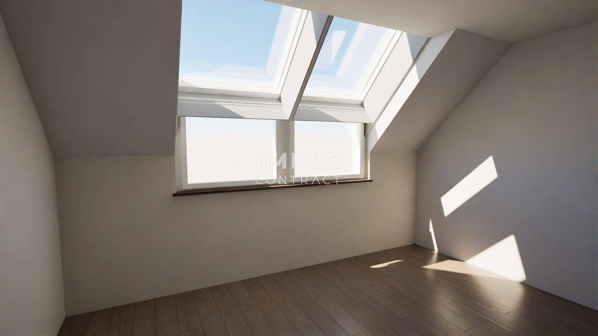 Leerer Raum im Dachgeschoss mit Holzboden und viel Tageslicht durch Dachfenster.