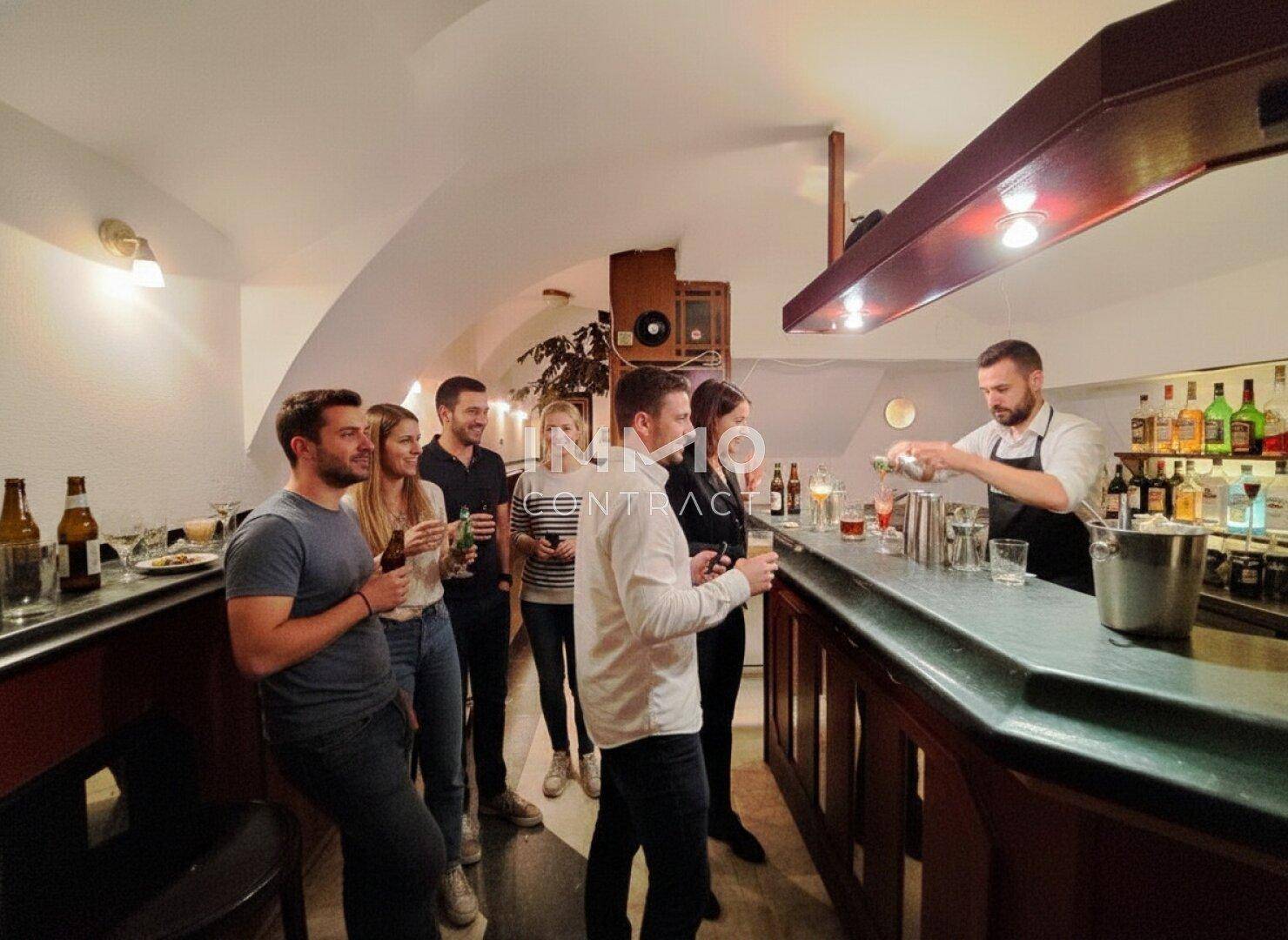 Lebhafte Bar mit gewölbter Decke, Holzelementen und Gästen, die Getränke genießen.
